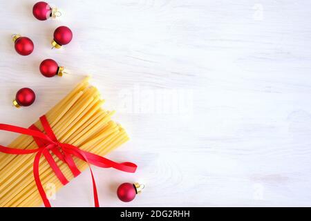 Repas de Noël sur fond de bois blanc. Coller. Décoration de Noël. Espace pour le texte, vue de dessus. Spaghetti. Banque D'Images