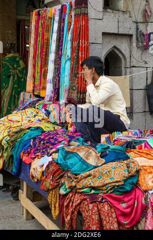 Vente de belles sarees colorées sur la rue commerçante de Hyderabad, vendeur attendant les clients, les clients occupés à faire du shopping Banque D'Images