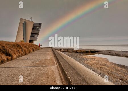 Rainbow à Rossall Beach, Fleetwood, Lancashire, Royaume-Uni. Le bâtiment de quatre étages situé sur la promenade extérieure de Rossall point est la tour Rossall Coastwatch. Banque D'Images