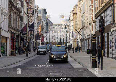 Un taxi londonien noir vous attend au feu sur New Bond Street. Londres Banque D'Images