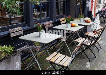 Tables extérieures avec chaises sur la terrasse du café à Amsterdam. Vintage Europe, vacances du nouvel an dans un style rétro. Café de rue pendant Noël avec des citrouilles Banque D'Images