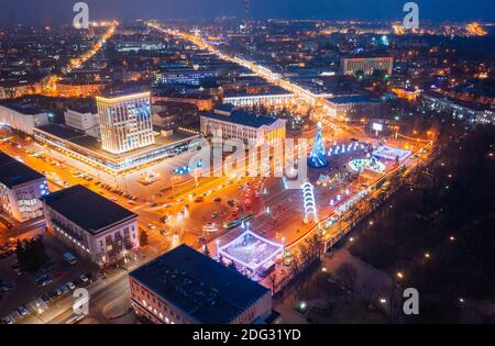 Gomel, Bélarus. Arbre de Noël principal et illumination festive sur la place Lénine à Homel. Nouvelle année en Biélorussie. Vue aérienne de nuit Banque D'Images