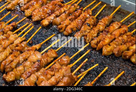 De savoureux bâtonnets de poulet au satay sur le gril Banque D'Images