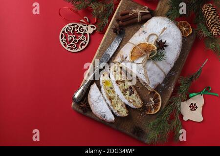 Noël savoureux stollen avec des fruits secs, des baies et des noix sur fond rouge. Gâteries traditionnelles allemandes. Vue de dessus Banque D'Images