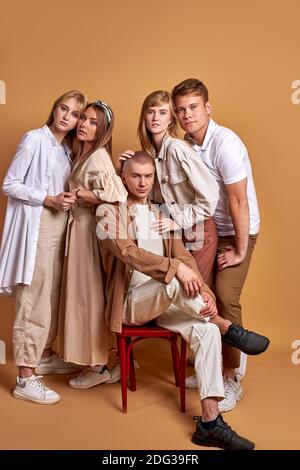 une équipe de jeunes en tricot serré se posant dans des vêtements tendance aux couleurs pastel, de beaux hommes et femmes se sont réunis Banque D'Images