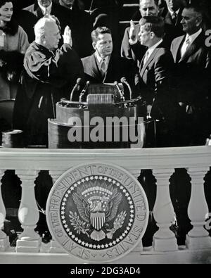 Le président des États-Unis John F. Kennedy est assermenté à titre de 35e président des États-Unis par le juge en chef des États-Unis Earl Warren, à gauche, sur le front est du Capitole des États-Unis à Washington, DC, États-Unis, le vendredi 20 janvier 1961. Photo par Arnie Sachs / CNP Banque D'Images