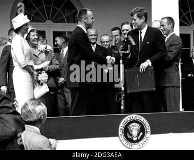 Le président des États-Unis John F. Kennedy félicite l'astronaute Alan B. Shepard, Jr., le premier américain dans l'espace, pour son parcours historique du 5 mai 1961 dans l'engin spatial Freedom 7 et lui remet le prix de service distingué de la National Aeronautics and Space Administration (NASA), à Washington, DC, États-Unis, le 6 mai, 1961. L'épouse de Shepard, Louise (laissée en robe blanche et chapeau), et sa mère étaient présents ainsi que les six autres astronautes de Mercury, dont le colonel John H. Glenn Jr. Et d'autres produits de la NASA, certains visibles en arrière-plan. Photo de la NASA via CNP Banque D'Images