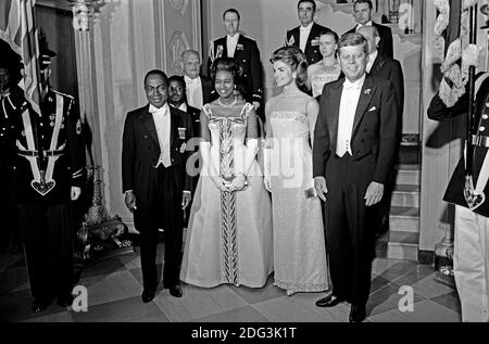 Le président des États-Unis John F. Kennedy et de la Première Dame Jacqueline Kennedy sont devant le grand escalier de la Maison Blanche à Washington, DC avant un dîner en l'honneur du président de la Côte d'Ivoire, Félix Houphouët-Boigny, et première dame de la Côte d'Ivoire, Marie-Thérèse Houphouët-Boigny le 22 mai 1962. Première rangée (L-R) : Le Président Houphouët-Boigny ; Mme Houphouët-Boigny ; Mme Kennedy ; le président Kennedy. Autres (L-R) : l'Ambassadeur de Côte d'Ivoire, Henri Konan Bédié, Ambassadeur des États-Unis à la Côte d'Ivoire, R. Borden rames militaires ; Assistant du Président Kennedy, le général Chester C. Clifton ; Ai Banque D'Images