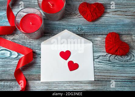 Deux coeurs rouges sur une enveloppe blanche sur un fond romantique. Banque D'Images