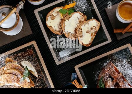 divers desserts avec thé sur fond noir Banque D'Images