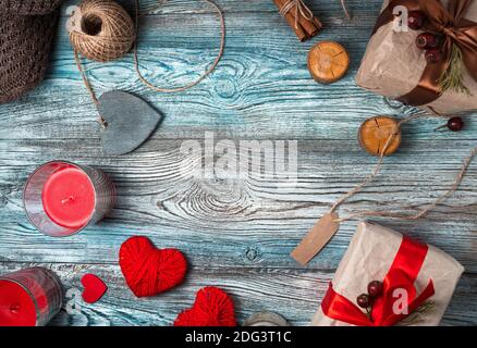 Coeurs et boîtes-cadeaux avec bougies sur fond de bois. Banque D'Images