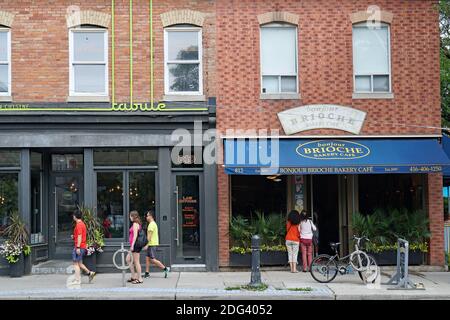 Toronto, Canada - le 28 juillet 2019 : les gens se promènent sur la rue Queen Easst devant les restaurants locaux et s'arrêtent pour lire le menu. Banque D'Images