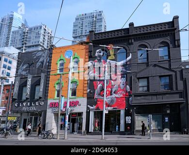 Toronto, Canada - le 19 juin 2019 : les acheteurs se promènent sur la rue Queen Ouest devant les magasins aux façades peintes en couleurs. Banque D'Images