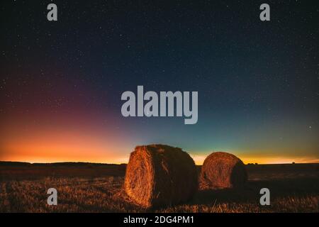 Comet Neolise C2020 F3 dans Starry Sky de nuit au-dessus de Haystacks dans le champ agricole d'été. Étoiles de nuit au-dessus du paysage rural avec balles de foin après Banque D'Images