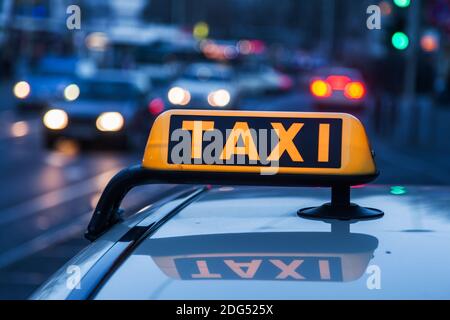 Panneau de taxi éclairé sur le toit d'un taxi au crépuscule Banque D'Images