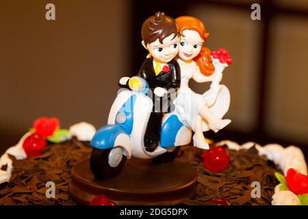 poupées de gâteau de mariage au chocolat en forme de mariage couple sur une moto Banque D'Images