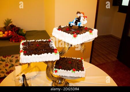 poupées de gâteau de mariage au chocolat en forme de mariage couple sur une moto Banque D'Images