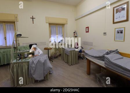Sœur Dometilla (75) travaille pour coudre des pièces de tissu pour une cérémonie à la basilique Saint-Pierre au Vatican le 2016 octobre. Des centaines de mètres de tissu « require des heures de travail et de patience. Nous sommes ici pour le faire", a commenté la sœur Dometilla. Comme l'horloge a frappé 12, la nonne a cessé de travailler assez longtemps pour se rendre au stoop où elle a récité la prière de l'Angelus. Chaque jour en même temps, complètement éloigné de l'agitation du monde extérieur, la vie au Vatican s'arrête complètement pour les quelques moments requis par le récital de cette prière au son des cloches Banque D'Images