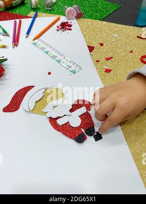 Gros plan de la main de fille faisant l'artisanat du Père Noël Banque D'Images