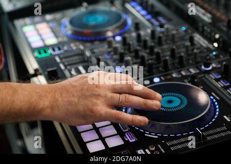 DJ jouant de la musique avec la manette de mixage audio. Mise au point sélective. Banque D'Images