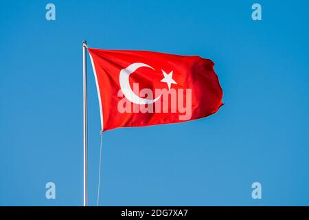 Drapeau turc volant sur le mât contre le ciel bleu. Drapeau turc Banque D'Images