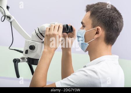 Dentiste à l'aide d'un microscope Banque D'Images