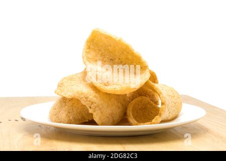 Pile de craqueur croquant de crevettes dans une assiette blanche sur une planche en bois Banque D'Images