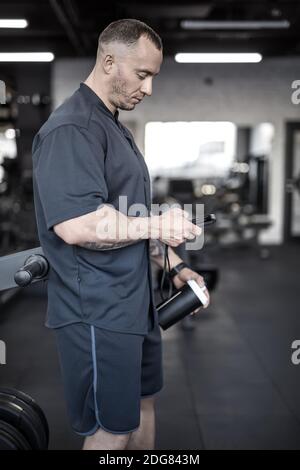 L'homme musclé a une pause dans la salle de gym Banque D'Images