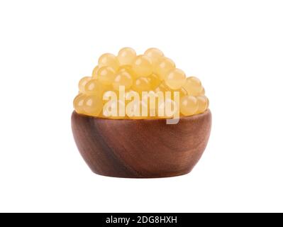 Perles de tapioca jaune pour le thé à bulles isolées sur fond blanc. Perles de tapioca dans un bol en bois. Banque D'Images