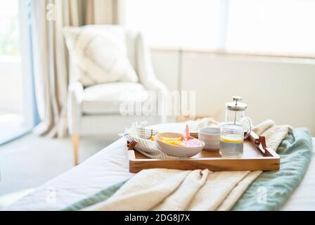 Plateau de petit déjeuner sur un lit tranquille du matin Banque D'Images