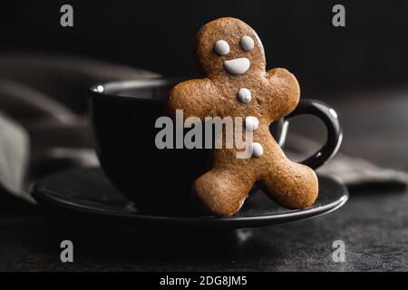 Pain d'épice de Noël et tasse de café sur table noire. Banque D'Images