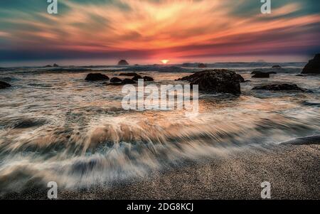 Plage rocheuse au coucher du soleil Banque D'Images