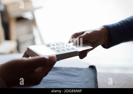 Gros plan sur un client avec une carte de crédit à l'aide de la fonction de lecture dans la boutique Banque D'Images