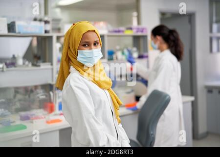 Portrait confiante scientifique féminine en hijab et masque facial Banque D'Images