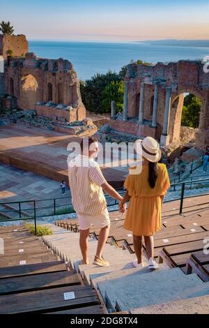 Taormina Sicile, couple regardant le coucher du soleil sur les ruines de l'ancien théâtre grec de Taormina, Sicile. Couple mi-âge sur les vacances Sicilia Banque D'Images