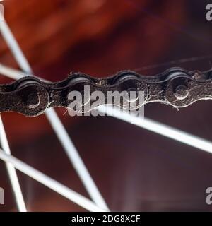 Chaîne de vélo sale sur le fond des rayons Banque D'Images