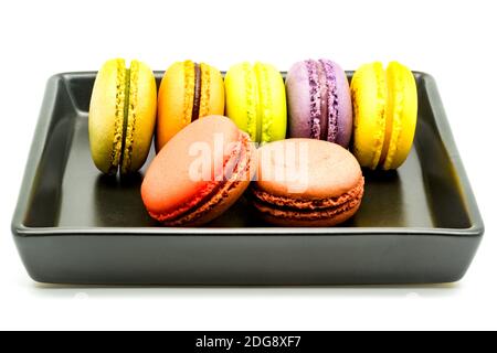 Rangée de macarons dans une assiette noire Banque D'Images