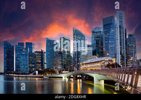 Vue imprenable sur le Merlion Park avec les gratte-ciel de Singapour en arrière-plan pendant un magnifique et spectaculaire coucher de soleil. Banque D'Images