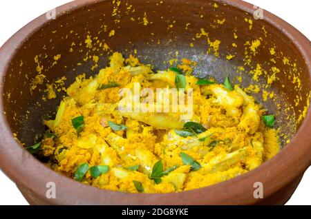 Gros plan de curry de poisson sec à la noix de coco de style Kerala cuit dans un pot de terre. Isolé. Banque D'Images