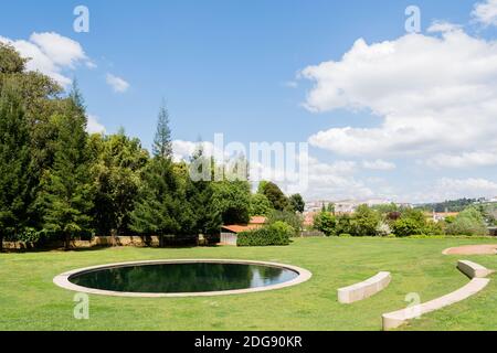 Un petit étang dans les jardins de Quinta das Lagrimas et des sièges en pierre à Coimbra, Portugal Banque D'Images