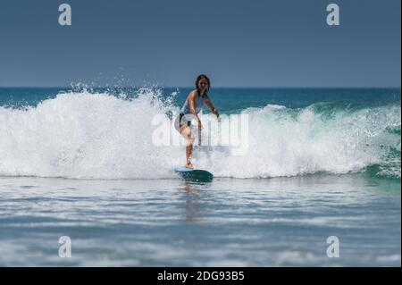 VARKALA, INDE - 14 mars 2020 : une femme surfant dans les vagues du Kerala Banque D'Images