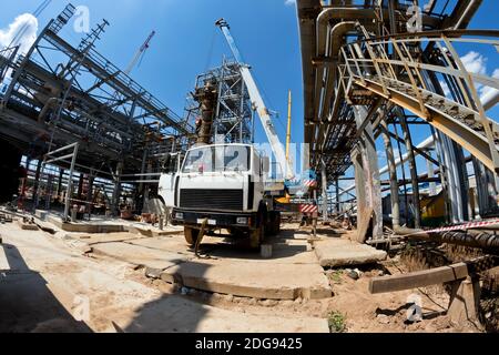 Grue de camion avec jambes étalées et flèche allongée est sur le chantier Banque D'Images