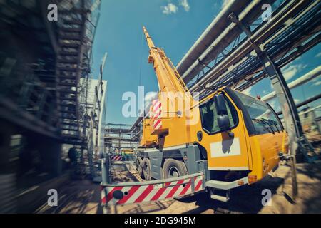 Grue de camion avec jambes étalées et flèche allongée est sur le chantier Banque D'Images