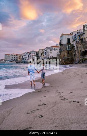 Couple en vacances Sicile visitant la vieille ville de Cefalu, coucher de soleil sur la plage de Cefalu Sicile, vieille ville de Cefalu Sicilia vue panoramique sur le village coloré.Italie Banque D'Images