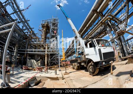 Grue de camion avec jambes étalées et flèche allongée est sur le chantier Banque D'Images