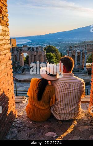 Taormina Sicile, couple regardant le coucher du soleil sur les ruines de l'ancien théâtre grec de Taormina, Sicile. Couple mi-âge sur les vacances Sicilia Banque D'Images