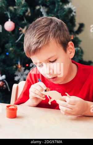 Mignon 7 ans enfant garçon peint en bois dinosaure jouet Pour arbre de Noël Banque D'Images