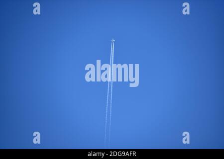 Avion d'aviation contre le ciel bleu laissant derrière lui une vapeur Trail ou contrail Photographie prise par Simon Dack Banque D'Images