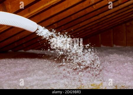 Pulvérisation de l'isolant en fibre de verre soufflé pour le toit - technicien en pulvérisation de mousse isolation à l'aide d'un pistolet à plusieurs composants Banque D'Images