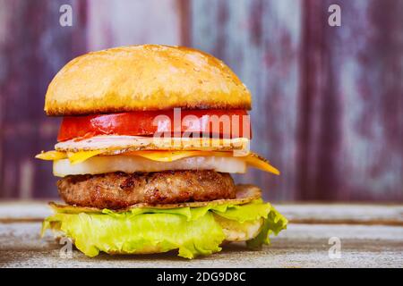 Cheeseburgers sur des viandes de bœuf et des ingrédients frais de salade servis avec sur une table en bois rustique Banque D'Images